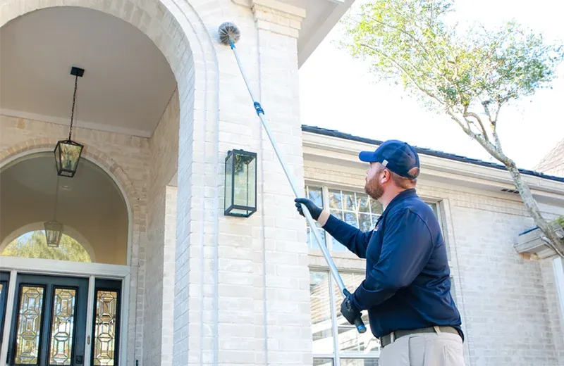 Justice Pest Service's technician sweeping entryway of home
